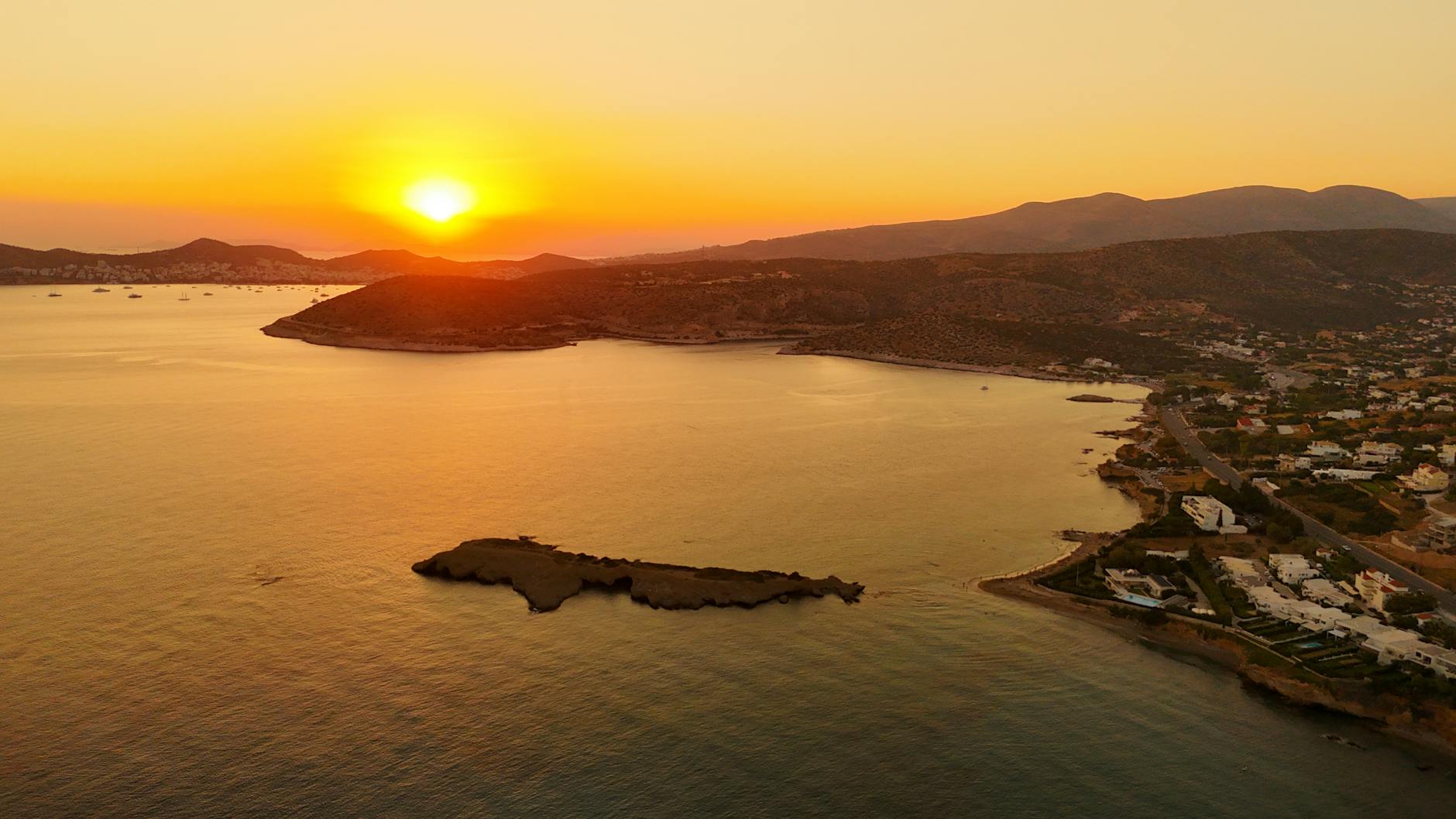 Greckie wybrzeże z lotu ptaka o zachodzie słońca nad morzem i górami