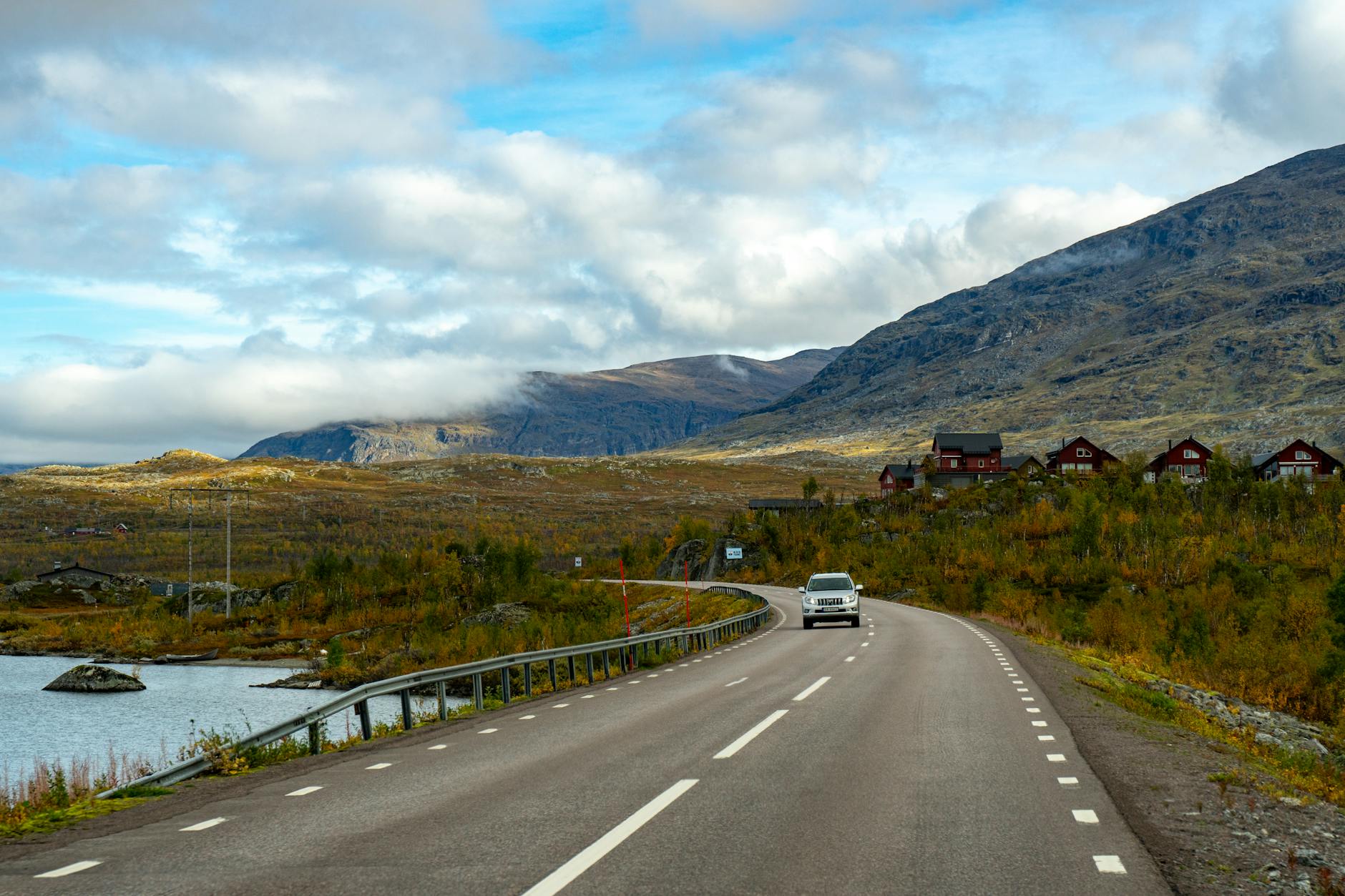Jesienna droga wśród gór w północnej Szwecji, widok z perspektywy kierowcy