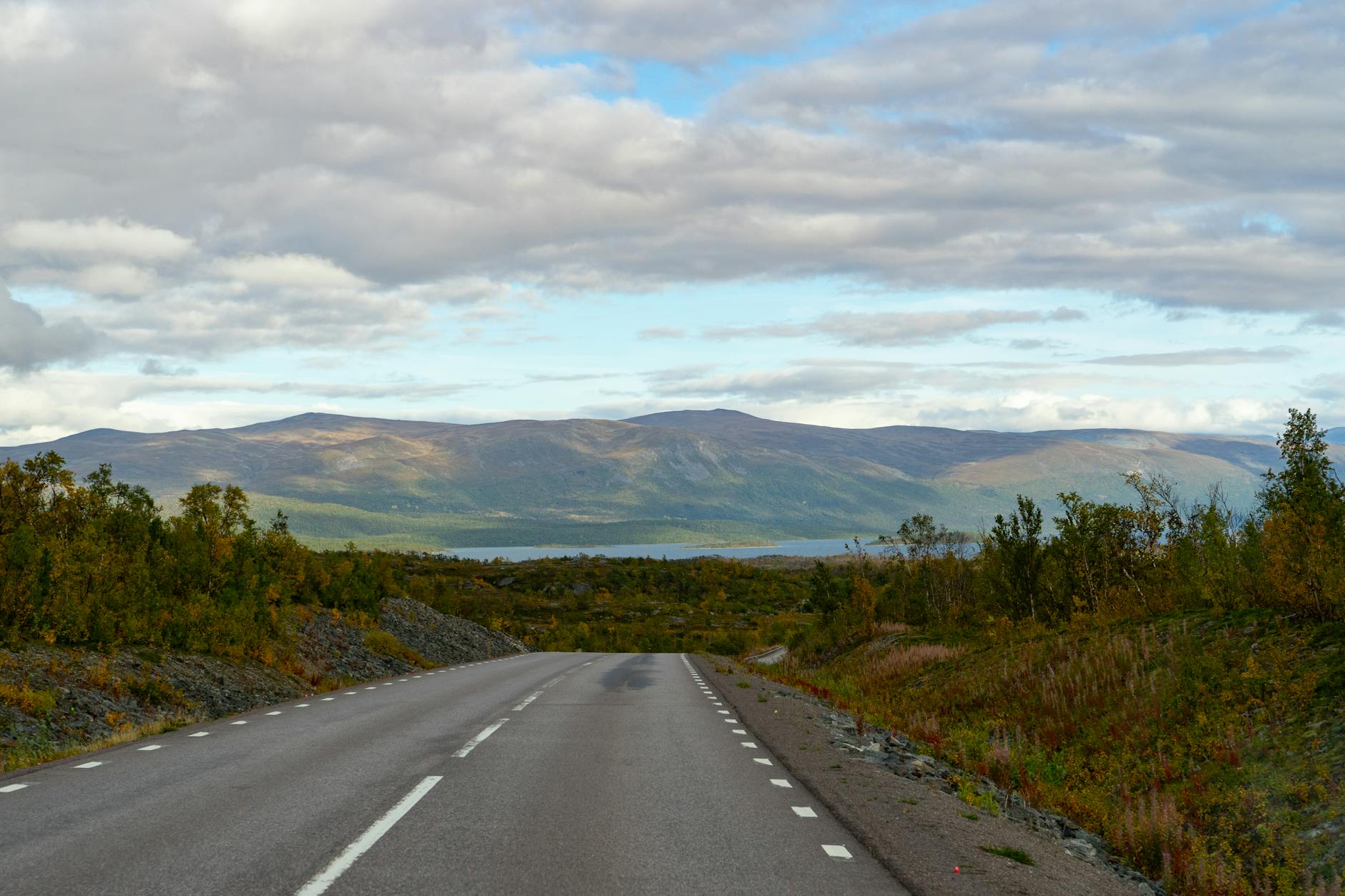 Pusta droga przez spokojny, górzysty krajobraz na północy Szwecji