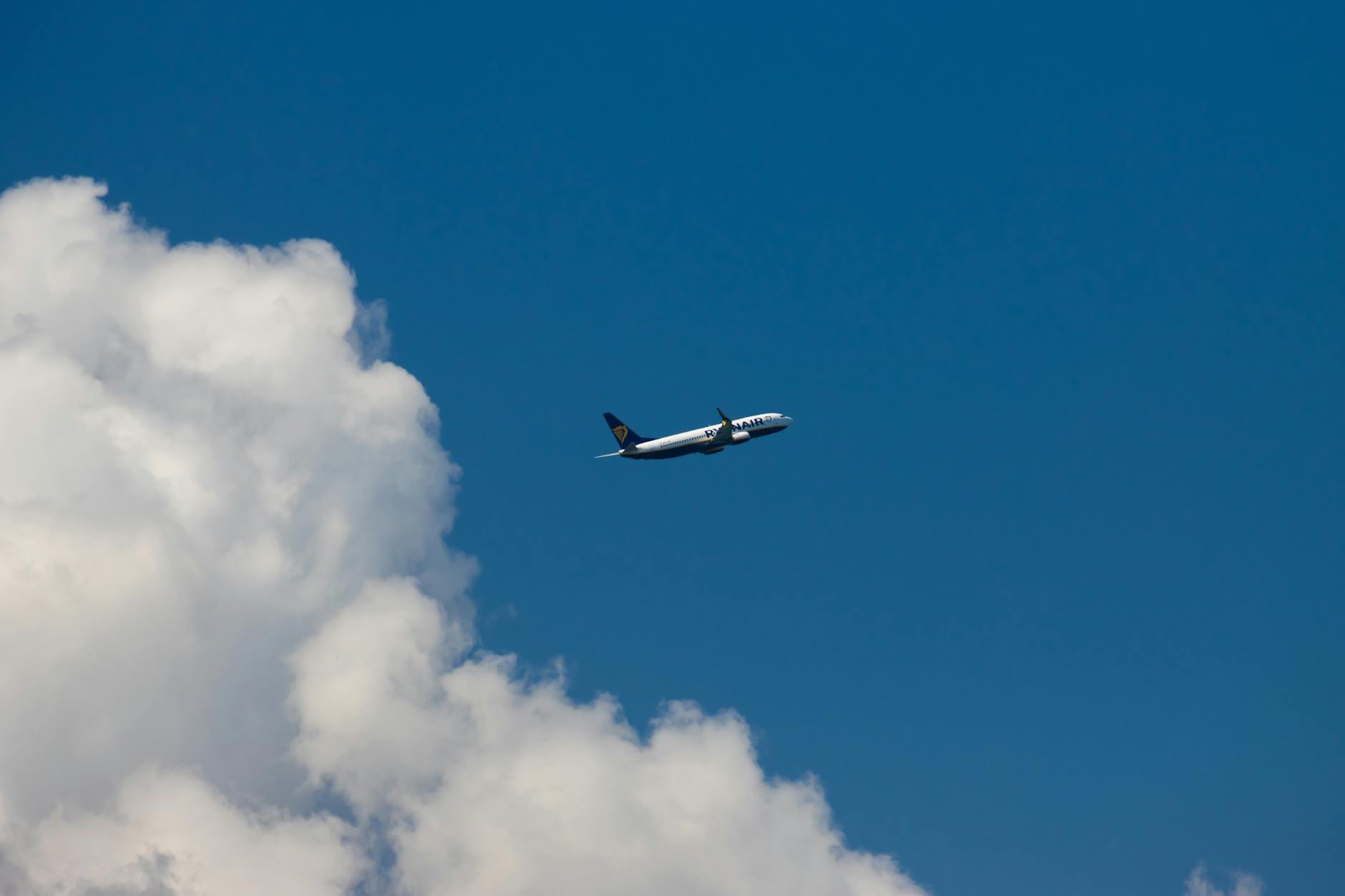 Samolot pasażerski nad Korfu na tle błękitnego nieba i chmur