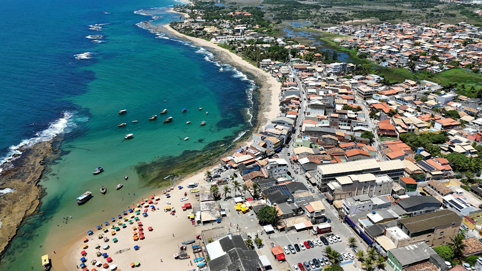 Kolorowe parasole na plaży Arembepe nad błękitnym morzem w Bahii