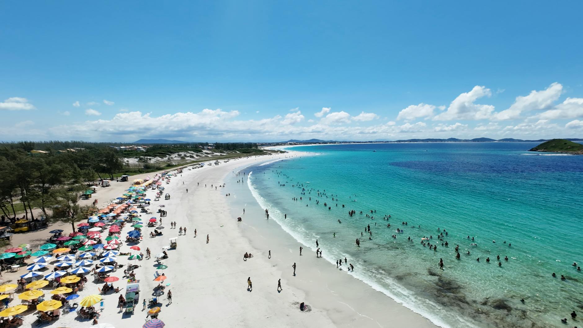 Tłoczna brazylijska plaża z kolorowymi parasolami widziana z lotu ptaka