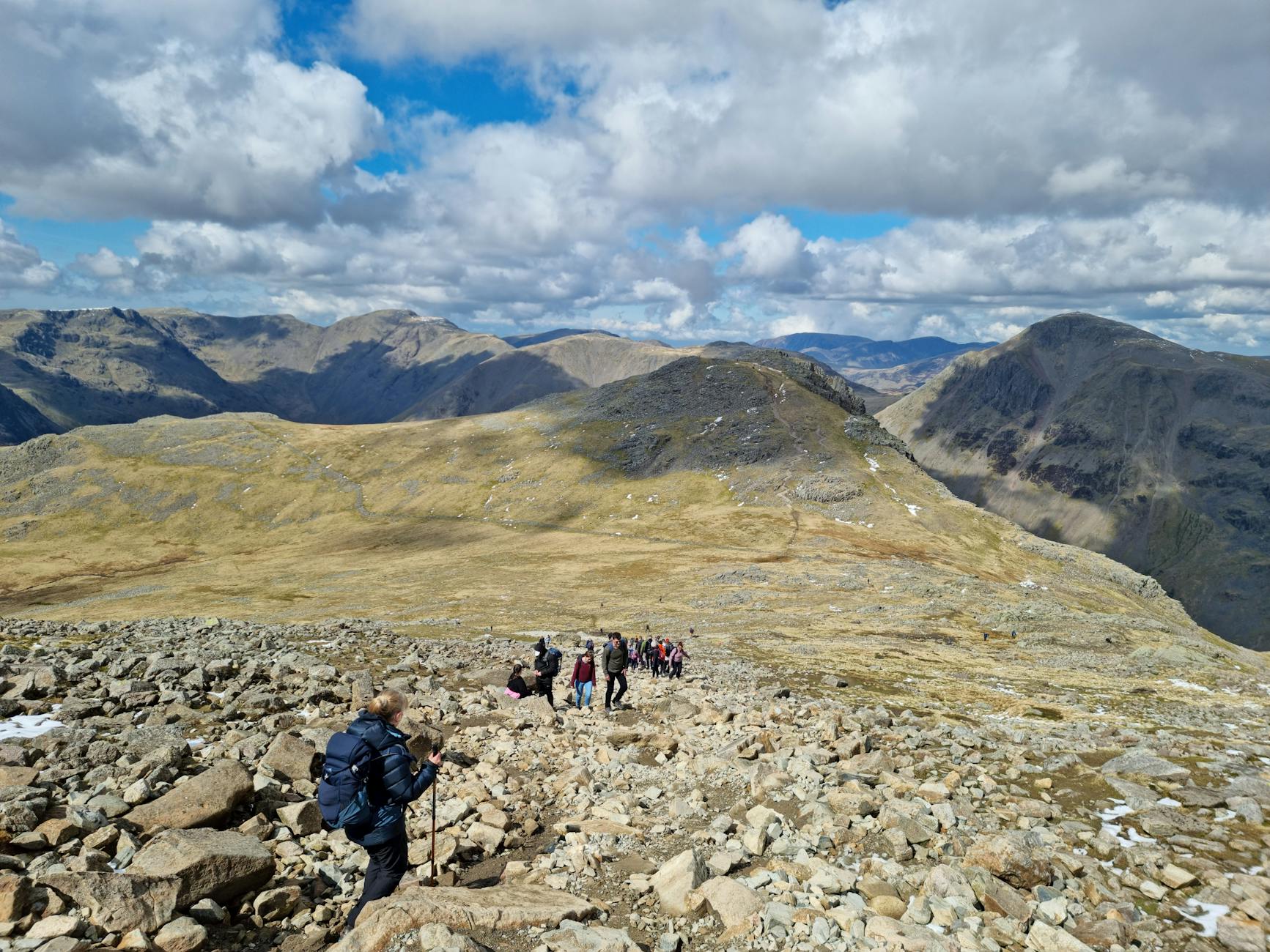 Turyści na skalistym szlaku w Lake District o zachodzie słońca